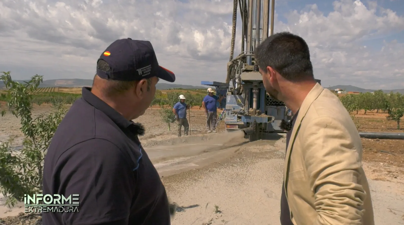 Fotograma del reportaje de Canal Extremadura: la máquina perforando un sondeo mientras el equipo trabaja en la finca
